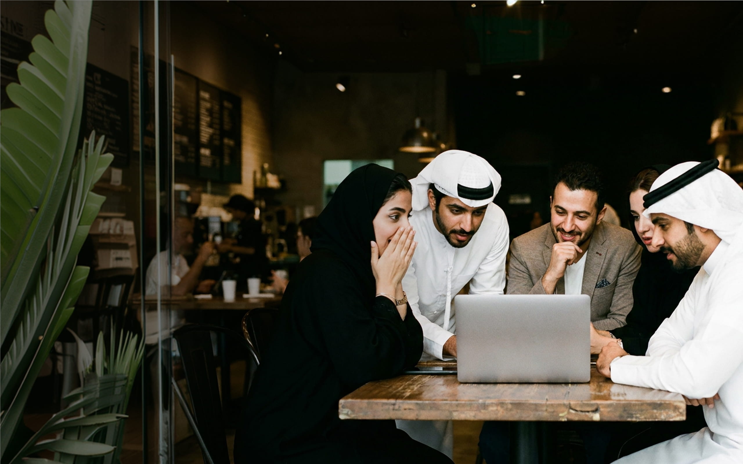 A team reviewing a portfolio together in Abu Dhabi